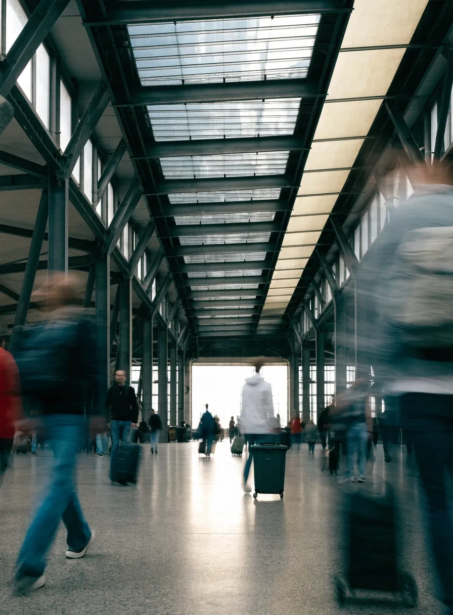 eye-level Czech railway station concourse with glass canopy daylight on a slab floor